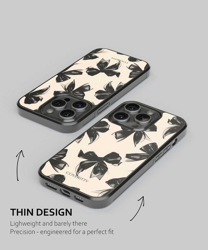 Two phone cases with black floral pattern on a gray background