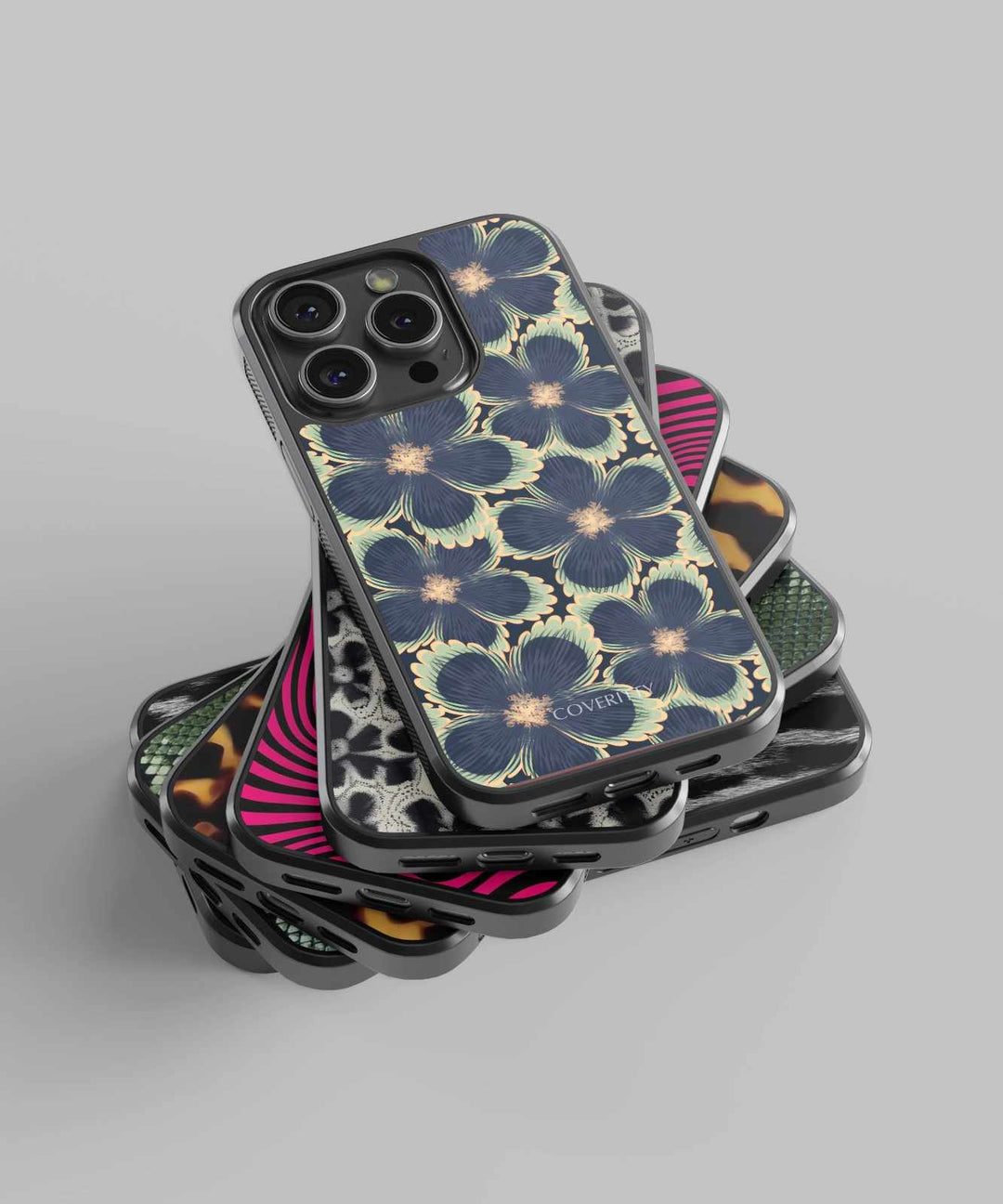 Stack of phone cases with floral and geometric designs on a gray background